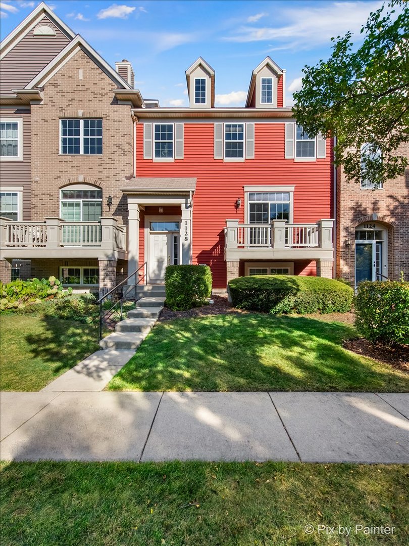 a front view of a house with a yard and potted plants