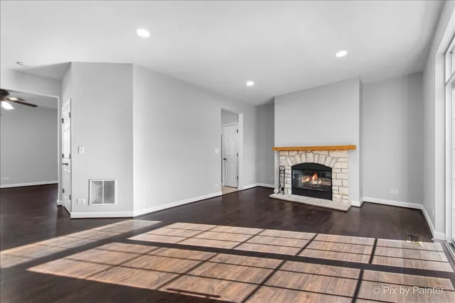 a view of empty room with a fireplace and wooden floor