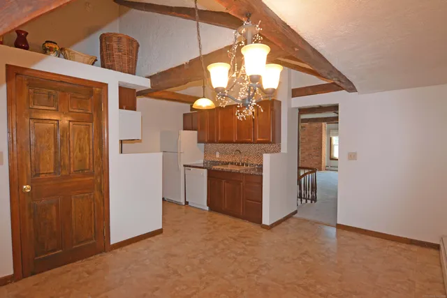 a view of a kitchen with a sink cabinets and entryway