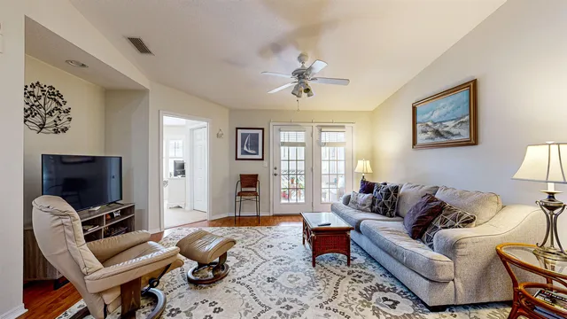 a living room with furniture a ceiling fan and a window