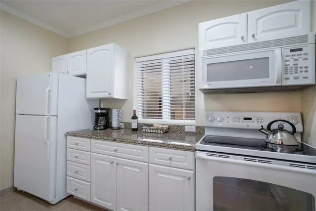a kitchen with appliances a sink and cabinets
