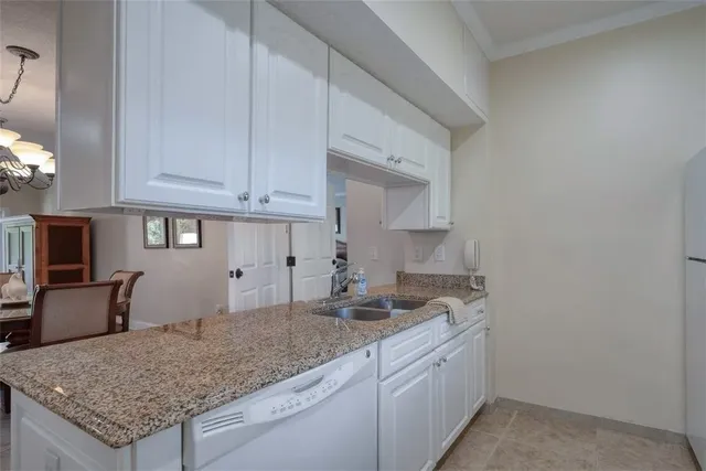 a kitchen with granite countertop a sink and a white stove