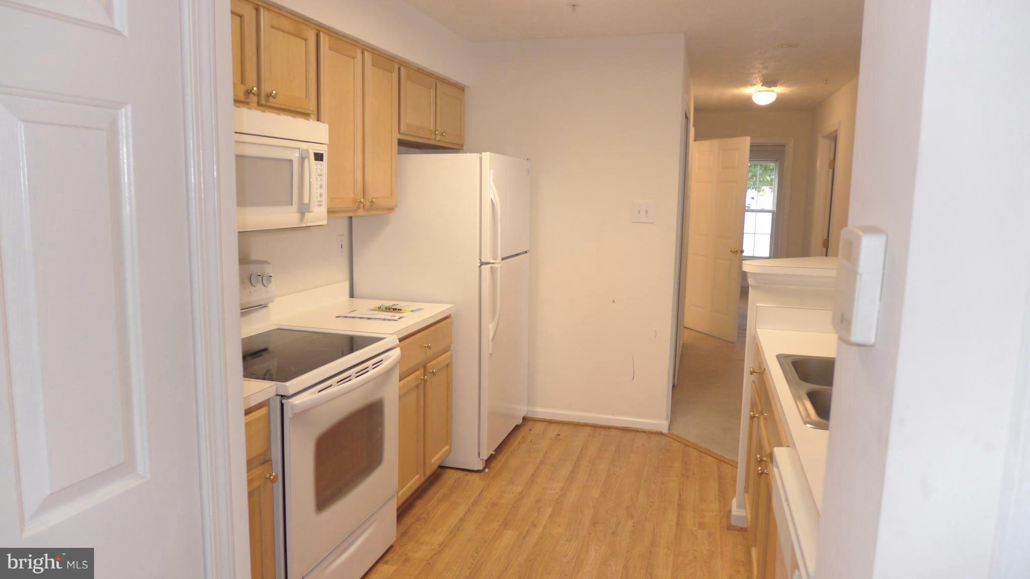 9746 Reese Farm Road, Unit 9746 Owings Mills, MD 21117 - Photo 11 of 22 a kitchen with a refrigerator a stove and a sink