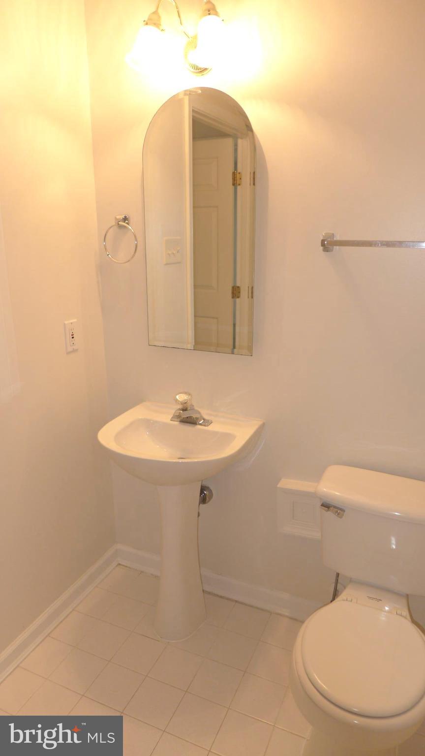 9746 Reese Farm Road, Unit 9746 Owings Mills, MD 21117 - Photo 21 of 22 a bathroom with a toilet a sink and mirror