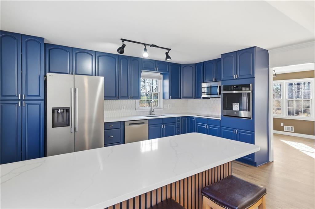 2810 Shaw Road Marietta, GA 30066 - Photo 13 of 38 a kitchen with stainless steel appliances granite countertop a refrigerator a sink dishwasher a stove and wooden cabinets with wooden floor