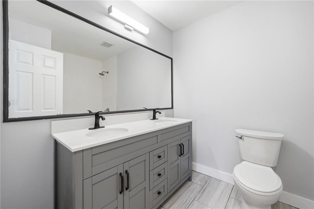 2810 Shaw Road Marietta, GA 30066 - Photo 16 of 38 a bathroom with a toilet sink a mirror and vanity