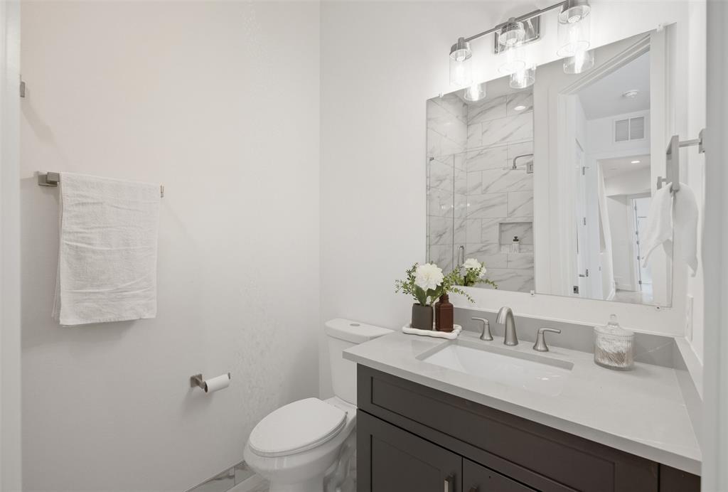 4517 Munger Avenue, Unit 101 Dallas, TX 75204 - Photo 19 of 39 a bathroom with a granite countertop sink a toilet and shower