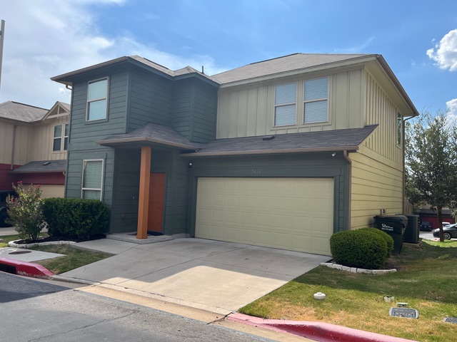5424 Falling Leaf Lane Austin, TX 78744 - Photo 1 of 18 a front view of a house with a yard and garage