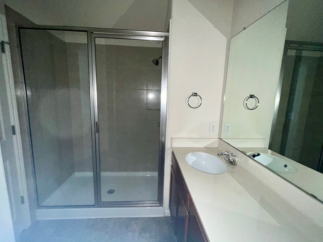 5424 Falling Leaf Lane Austin, TX 78744 - Photo 11 of 18 a bathroom with a shower sink and mirror