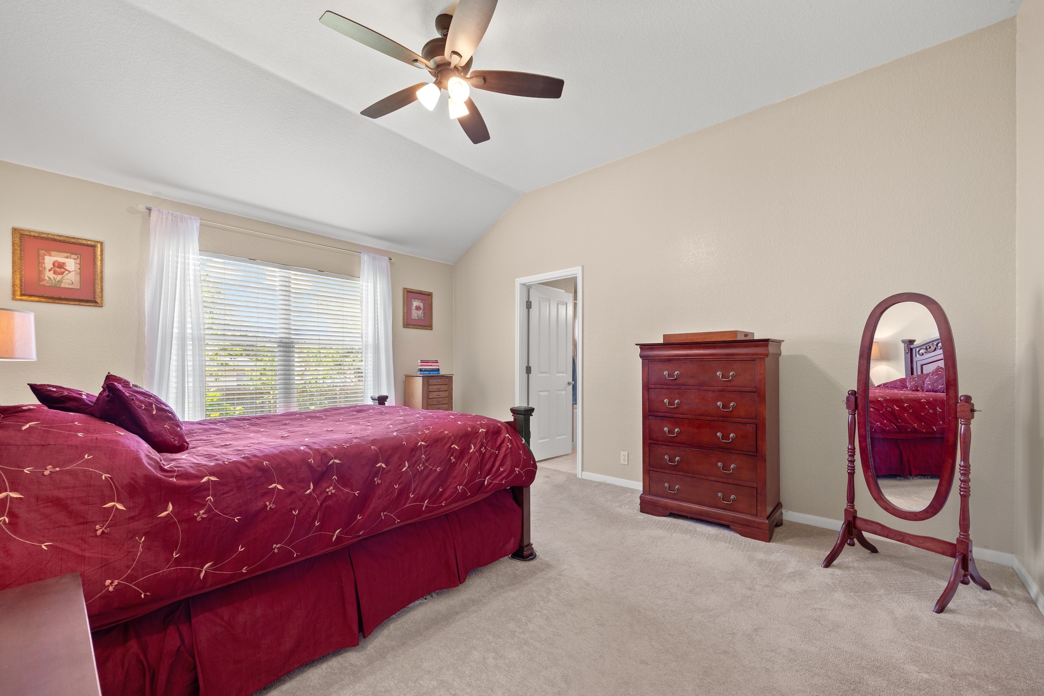 1108 Springbrook Road Pflugerville, TX 78660 - Photo 19 of 37 Lofty vaulted ceilings and plush carpeting enhance this serene primary bedroom retreat.