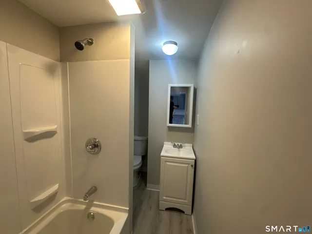 a bathroom with a toilet and a shower