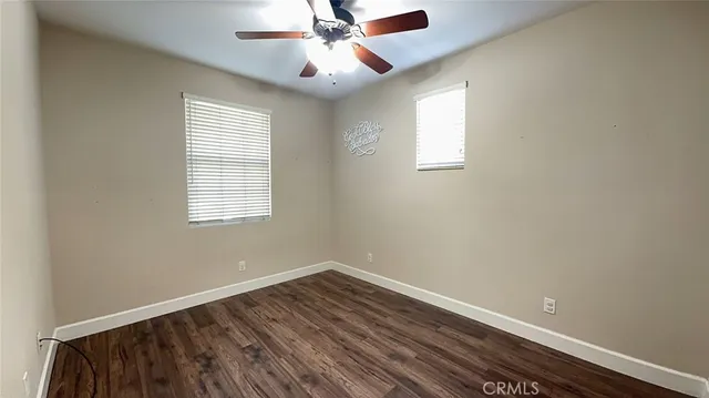an empty room with a window and wooden floor