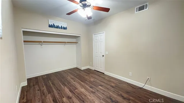 an empty room with a window and ceiling fan