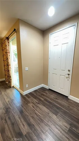 an empty room with wooden floor and door