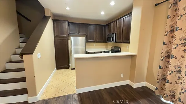 a kitchen with stainless steel appliances granite countertop a refrigerator and a sink