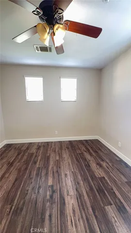 a view of a room with wooden floor and fan