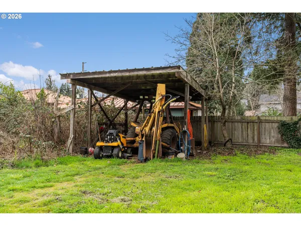 a view of a backyard with wooden fence and a table
