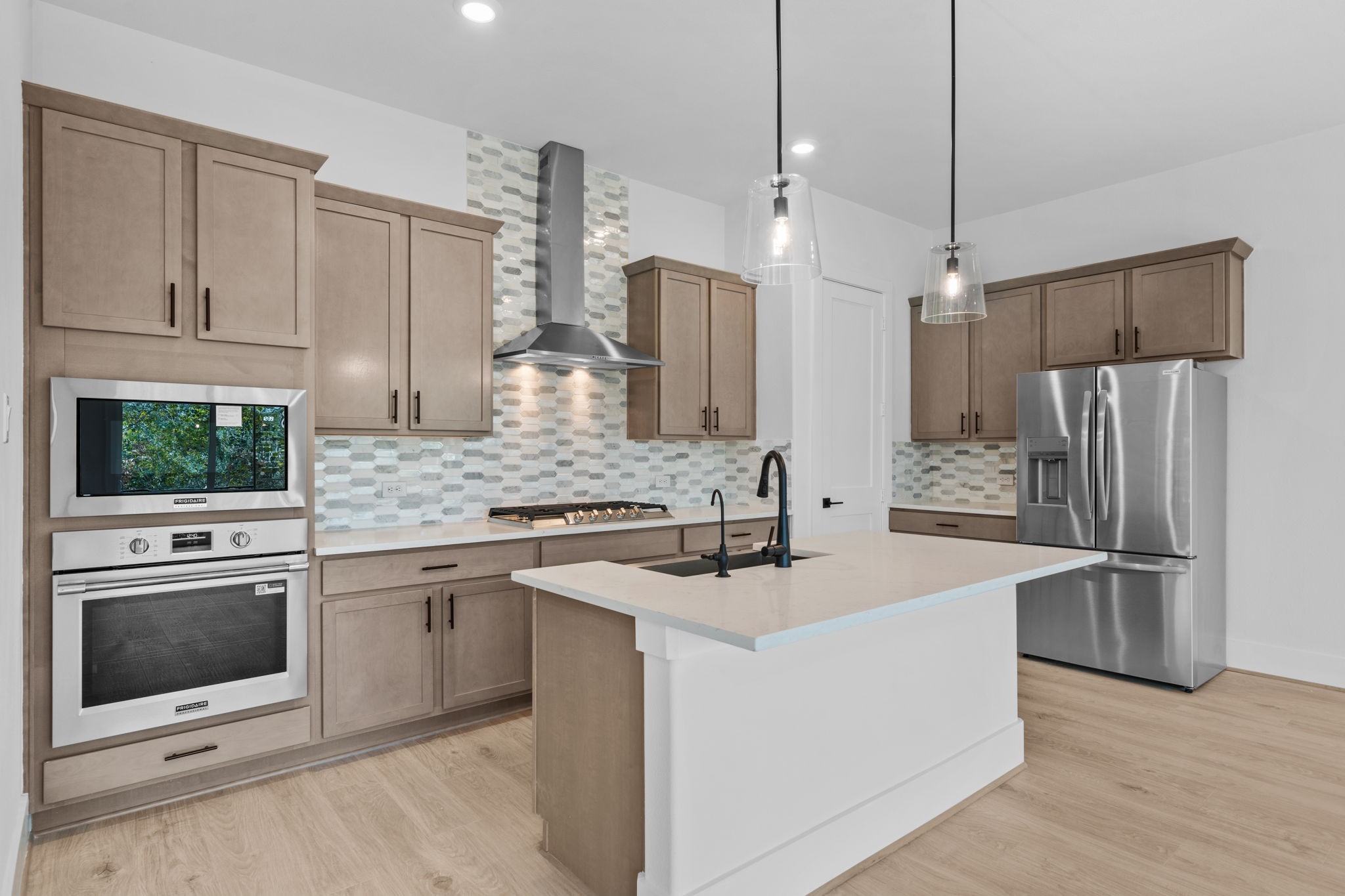 318 Terra Reserve Place Houston, TX 77079 - Photo 7 of 36 a kitchen with stainless steel appliances granite countertop a sink stove a refrigerator and a oven with wooden floor