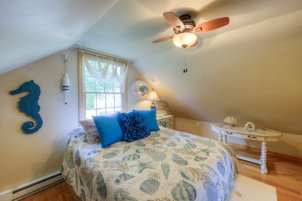 1 Factory Street Sandwich, MA 02563 - Photo 13 of 38 a bedroom with a bed and a chandelier