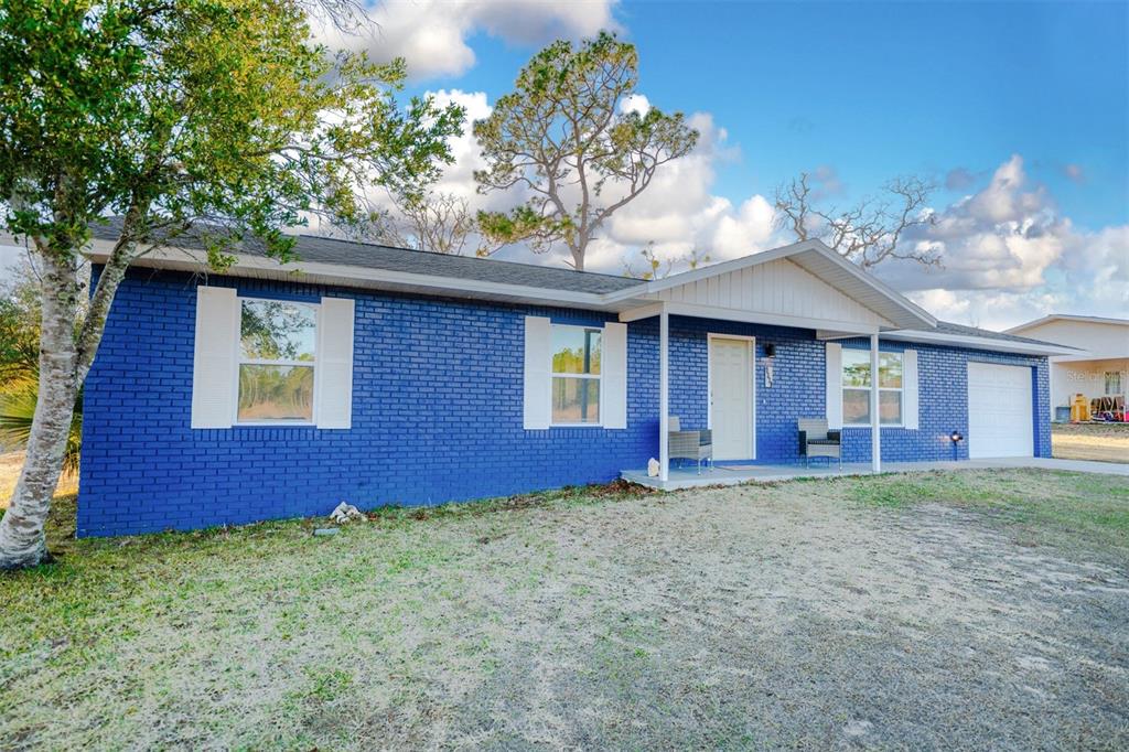 9330 Southeast Maricamp Road Ocala, FL 34472 - Photo 3 of 19 a view of a yard in front of a house with large trees