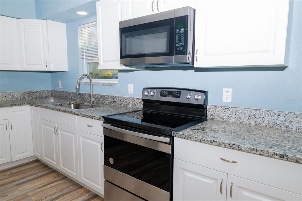 9330 Southeast Maricamp Road Ocala, FL 34472 - Photo 10 of 19 a kitchen with granite countertop a stove sink and microwave