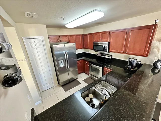 a kitchen with granite countertop stainless steel appliances and wooden cabinets