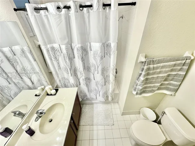 a bathroom with a sink a toilet and shower curtain