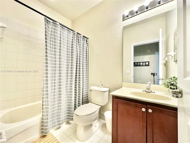 a bathroom with a sink a toilet and shower curtain