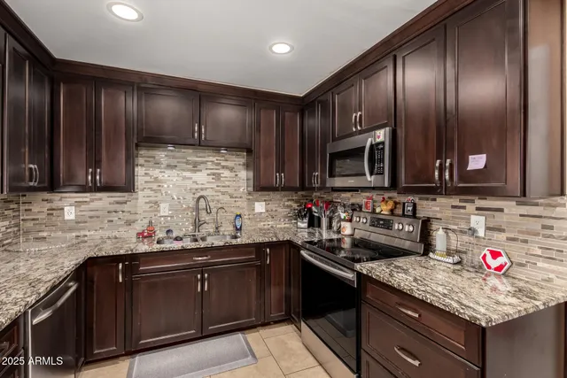 a kitchen with stainless steel appliances granite countertop a sink stove and cabinets