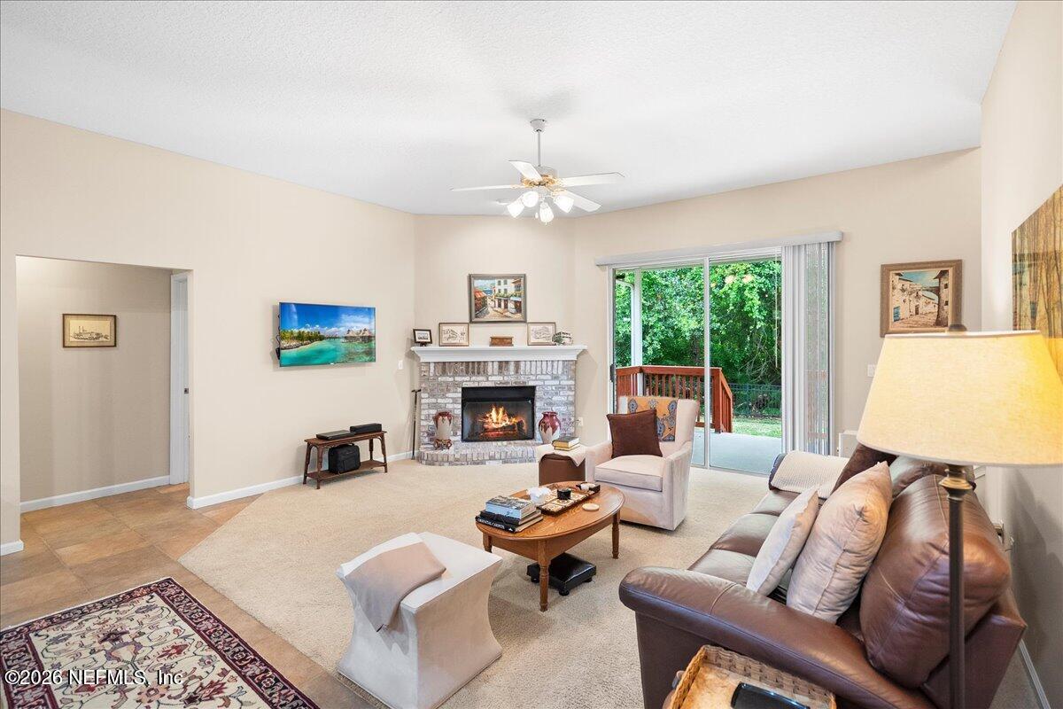 2489 Tall Cedars Road Fleming Island, FL 32003 - Photo 15 of 72 a living room with furniture a fireplace and a table
