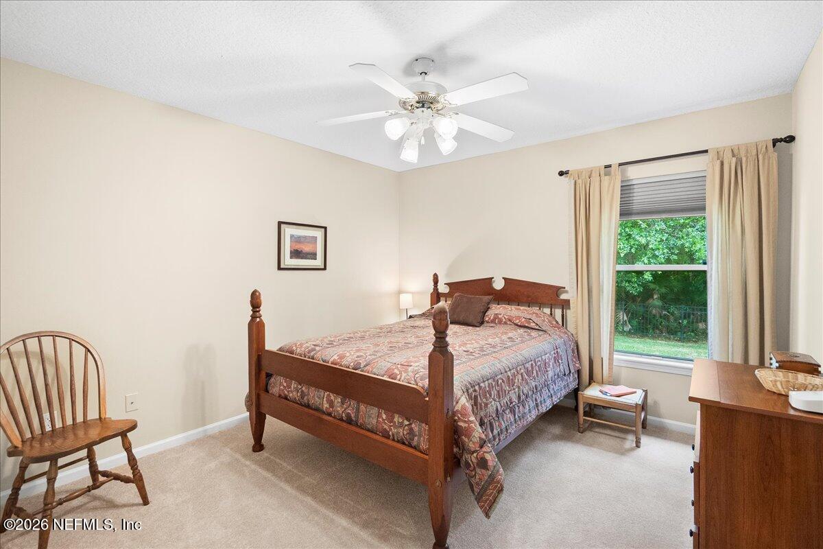 2489 Tall Cedars Road Fleming Island, FL 32003 - Photo 18 of 72 a bedroom with a bed and a chandelier
