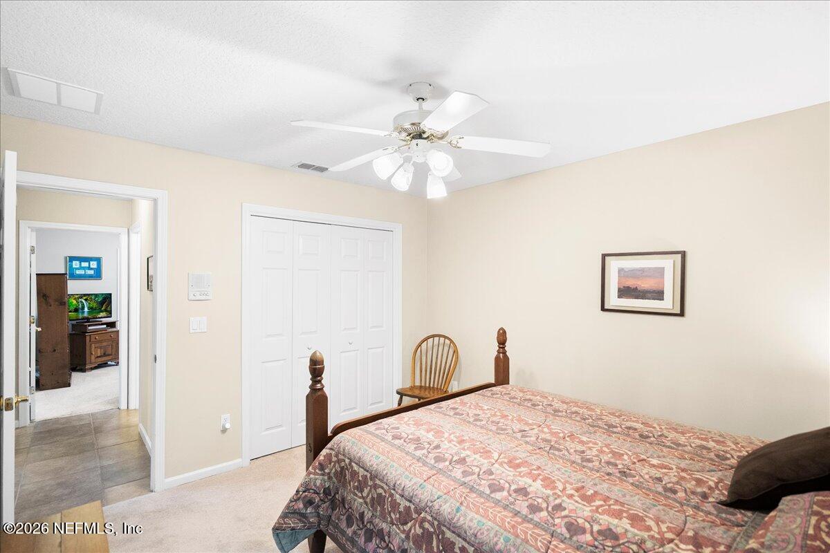 2489 Tall Cedars Road Fleming Island, FL 32003 - Photo 19 of 72 a bedroom with a bed and a chandelier