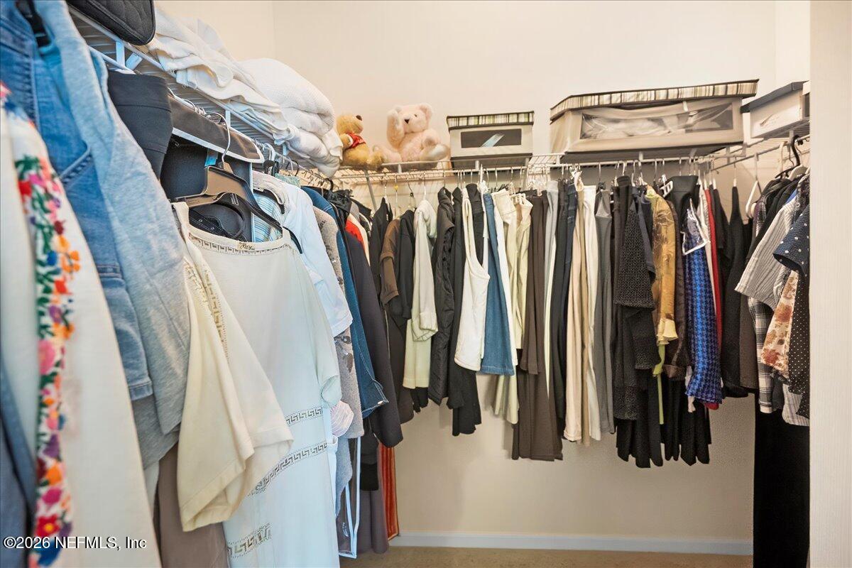 2489 Tall Cedars Road Fleming Island, FL 32003 - Photo 22 of 72 a view of walk in closet with clothes and shoes