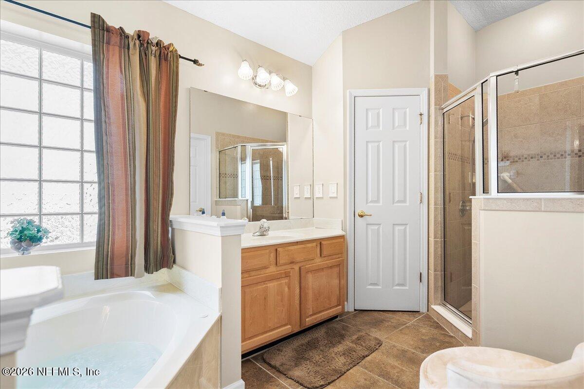 2489 Tall Cedars Road Fleming Island, FL 32003 - Photo 23 of 72 a bathroom with a tub sink and mirror