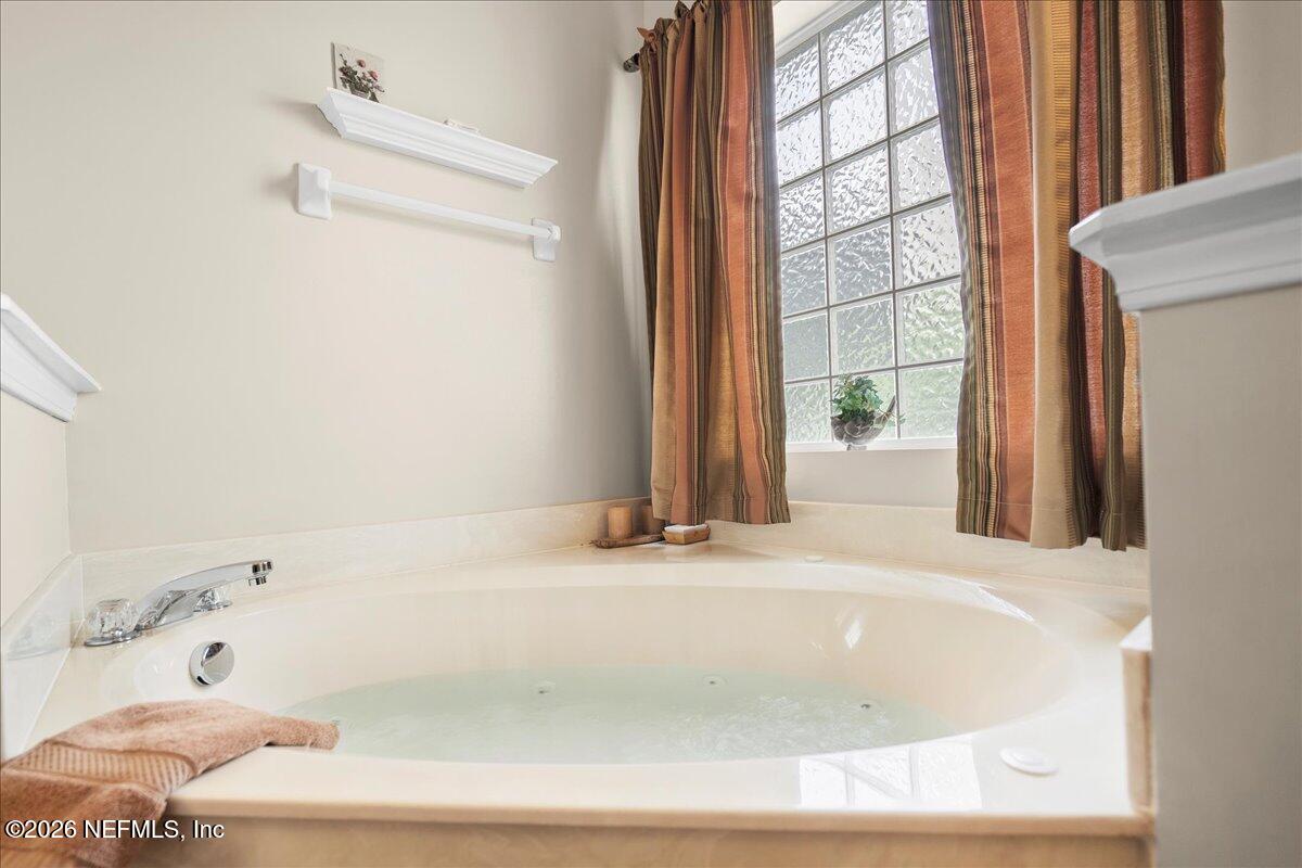 2489 Tall Cedars Road Fleming Island, FL 32003 - Photo 24 of 72 a bathroom with a bathtub and a window