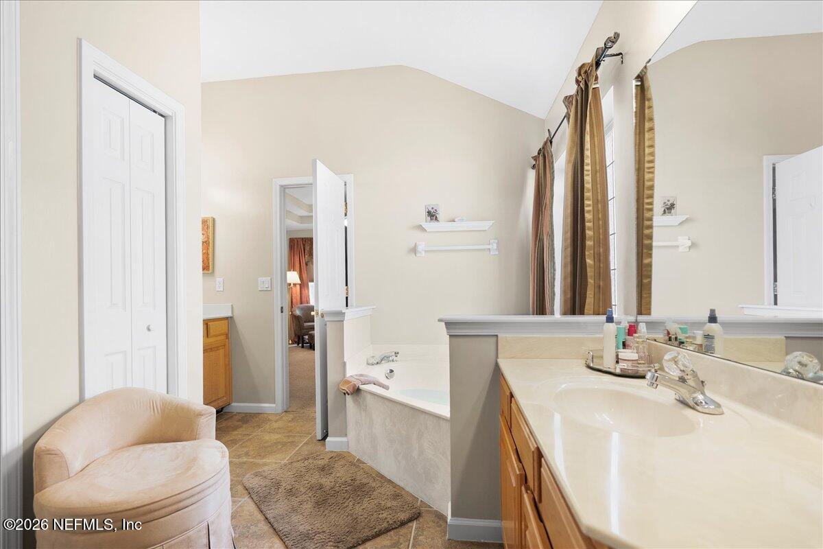 2489 Tall Cedars Road Fleming Island, FL 32003 - Photo 25 of 72 a spacious bathroom with a granite countertop sink and a mirror