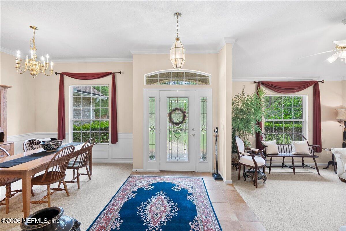 2489 Tall Cedars Road Fleming Island, FL 32003 - Photo 3 of 72 a living room with furniture a table and a chandelier