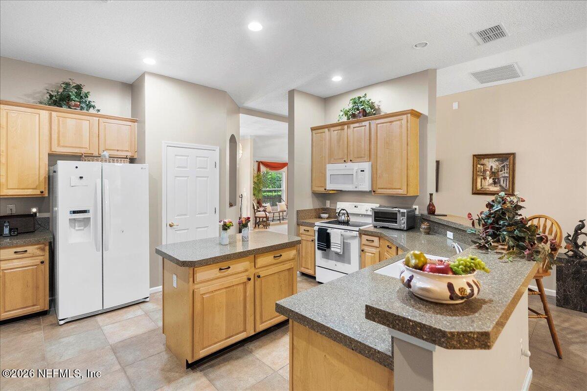 2489 Tall Cedars Road Fleming Island, FL 32003 - Photo 10 of 72 a kitchen with white cabinets and living room