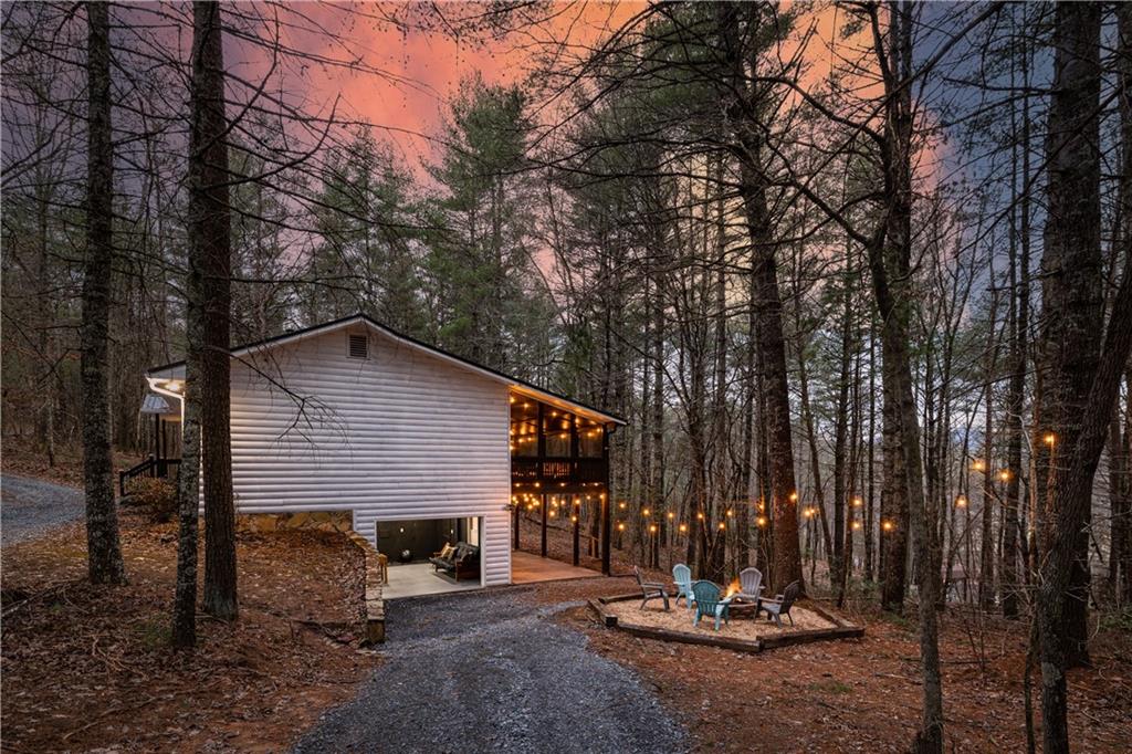 a view of a house with backyard and trees