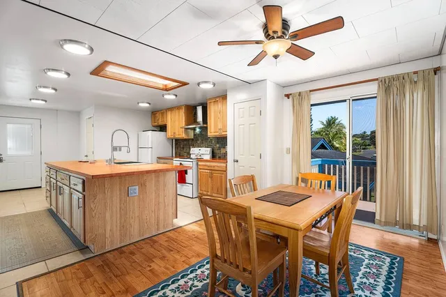 a kitchen with stainless steel appliances kitchen island granite countertop a table chairs and a refrigerator
