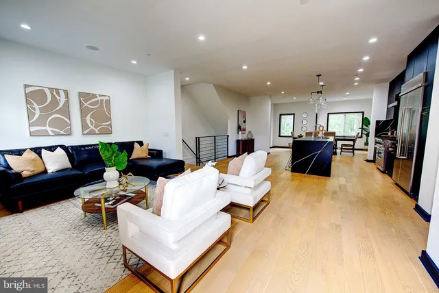a living room with furniture and a dining table with kitchen view