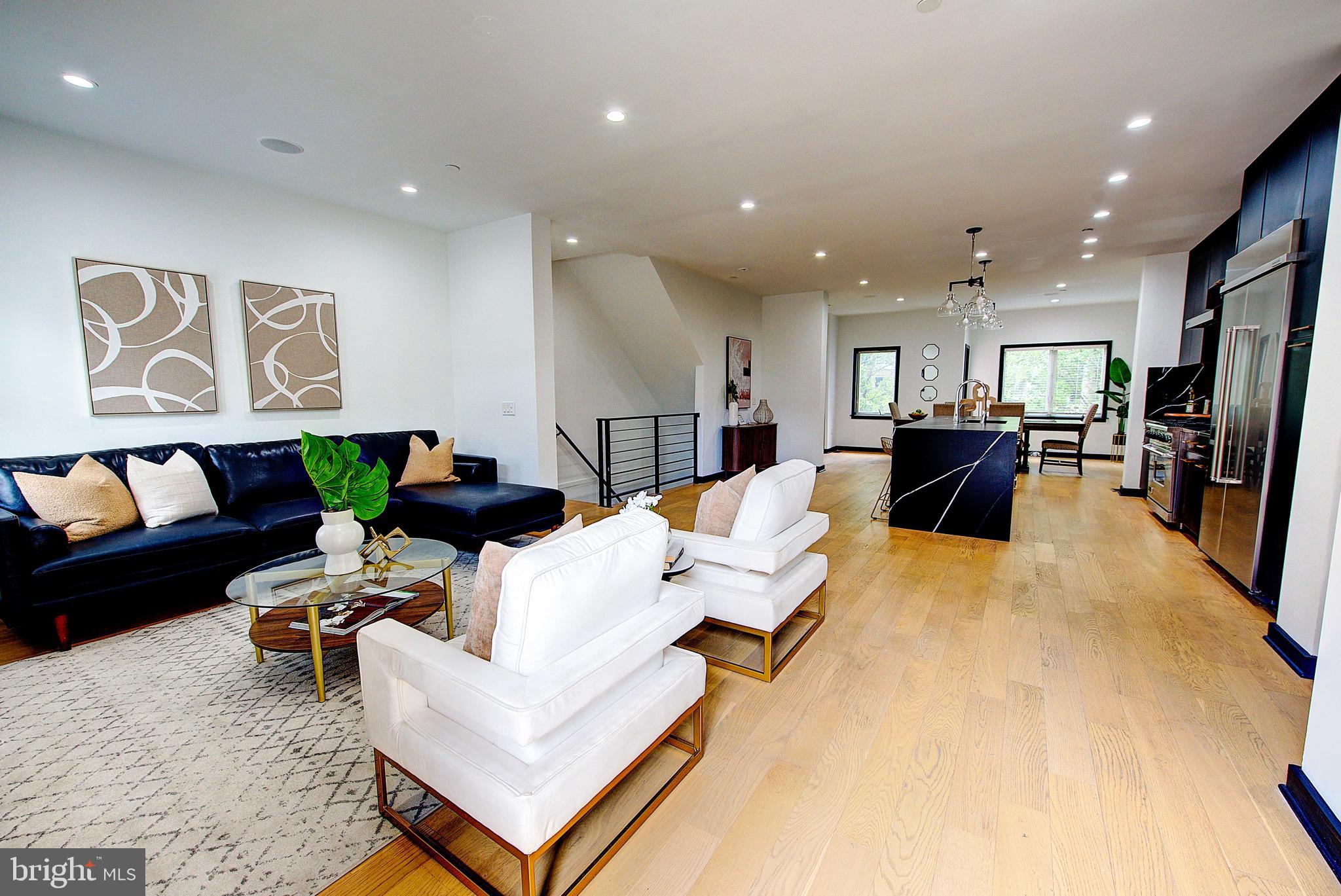 a living room with furniture and a dining table with kitchen view