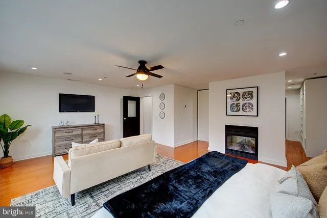 a walk in closet with wooden floor and a bathroom