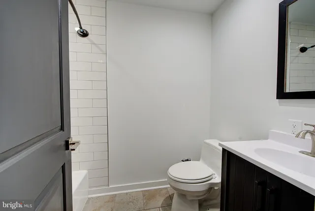 a bathroom with a toilet a sink and mirror