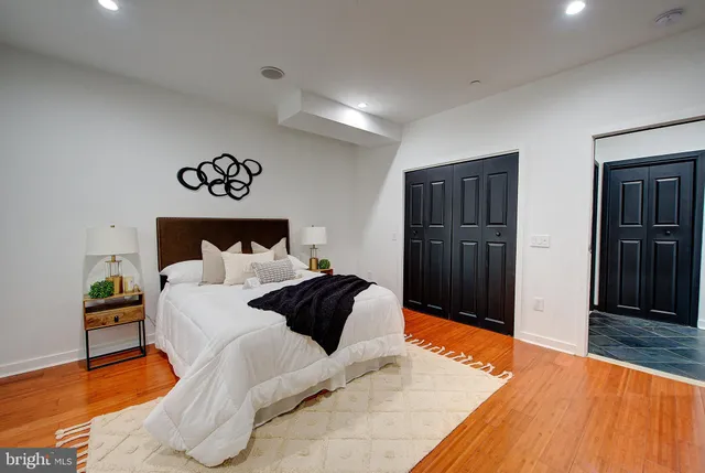 a bathroom with a granite countertop sink a toilet a mirror and shower