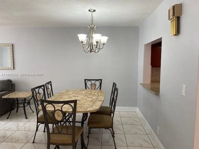 a view of a dining room with furniture and chandelier