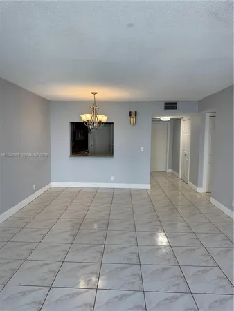 an empty room with closet and a chandelier fan