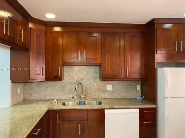 a kitchen with stainless steel appliances granite countertop wooden cabinets and a counter top space