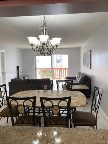 a view of a dining room with furniture and chandelier