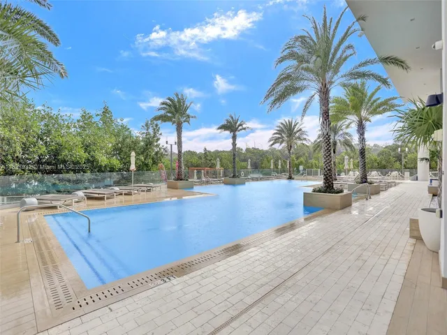 a view of swimming pool with palm trees